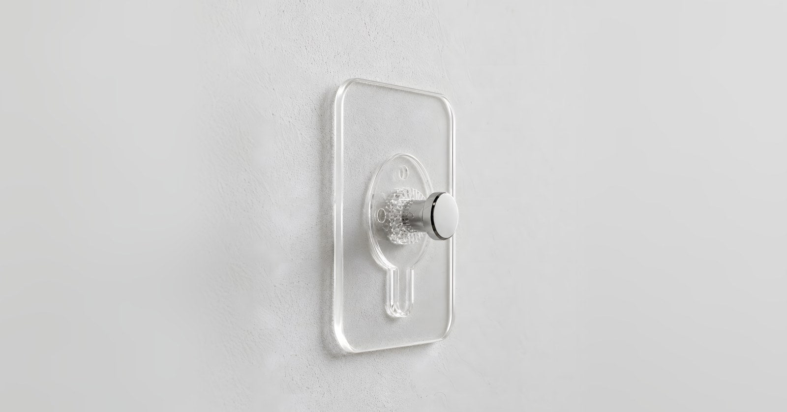 Crochet adhésif transparent posé sur un mur blanc, fourni avec chaque tableau