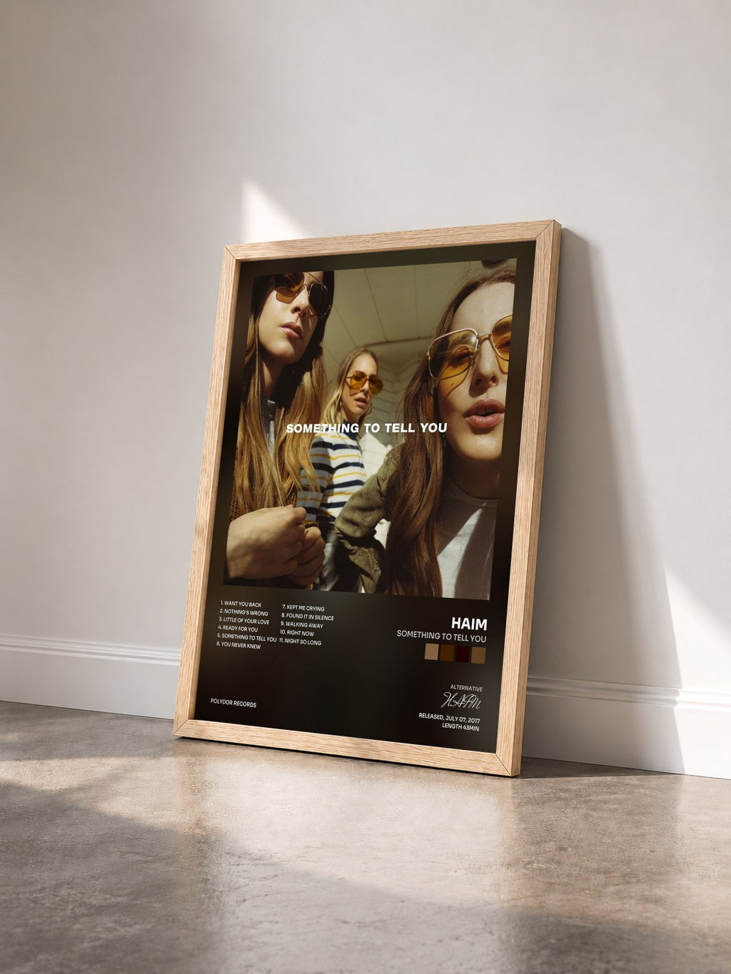 #bois Tableau de l'album Something To Tell You de HAIM vu de trois quarts, cadre en bois brut