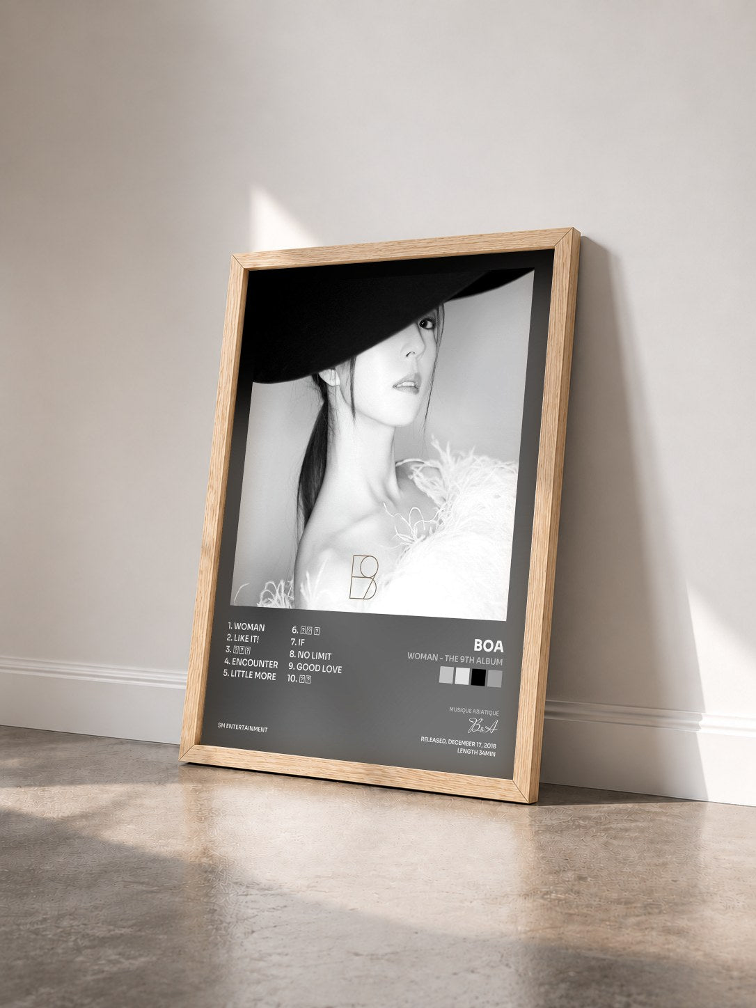 #bois Tableau de l'album WOMAN - The 9th Album de BoA vu de trois quarts, cadre en bois brut