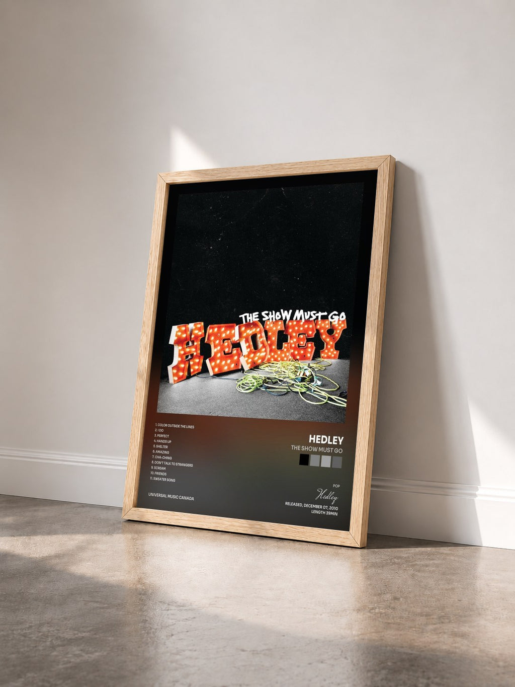 #bois Tableau de l'album The Show Must Go de Hedley vu de trois quarts, cadre en bois brut