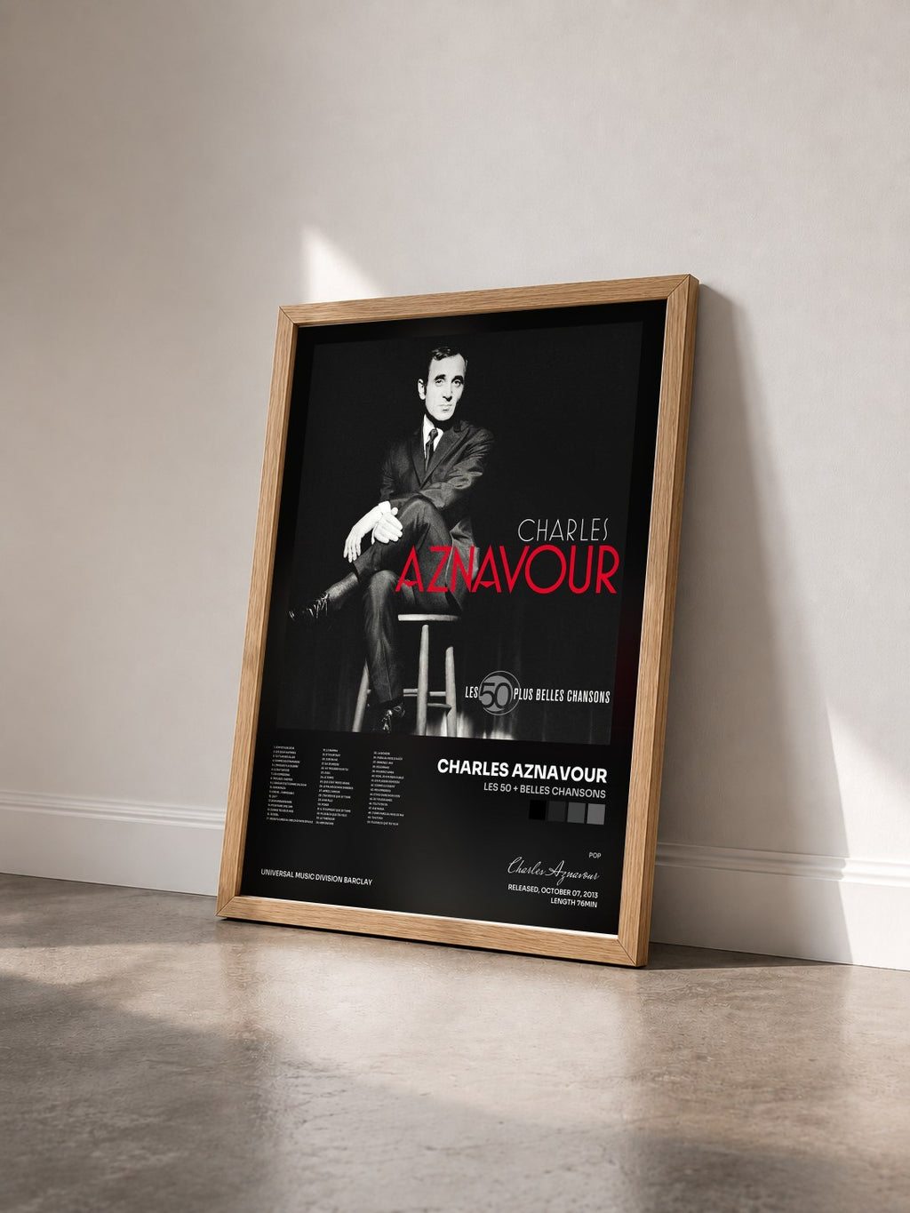 #bois Tableau de l'album Les 50 + Belles Chansons de Charles Aznavour vu de trois quarts, cadre en bois brut