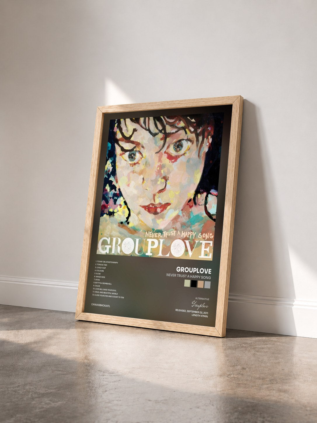 #bois Tableau de l'album Never Trust a Happy Song de Grouplove vu de trois quarts, cadre en bois brut