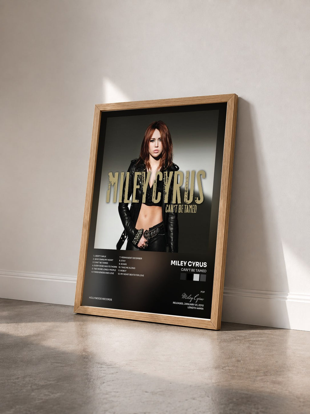 #bois Tableau de l'album Can't Be Tamed de Miley Cyrus vu de trois quarts, cadre en bois brut