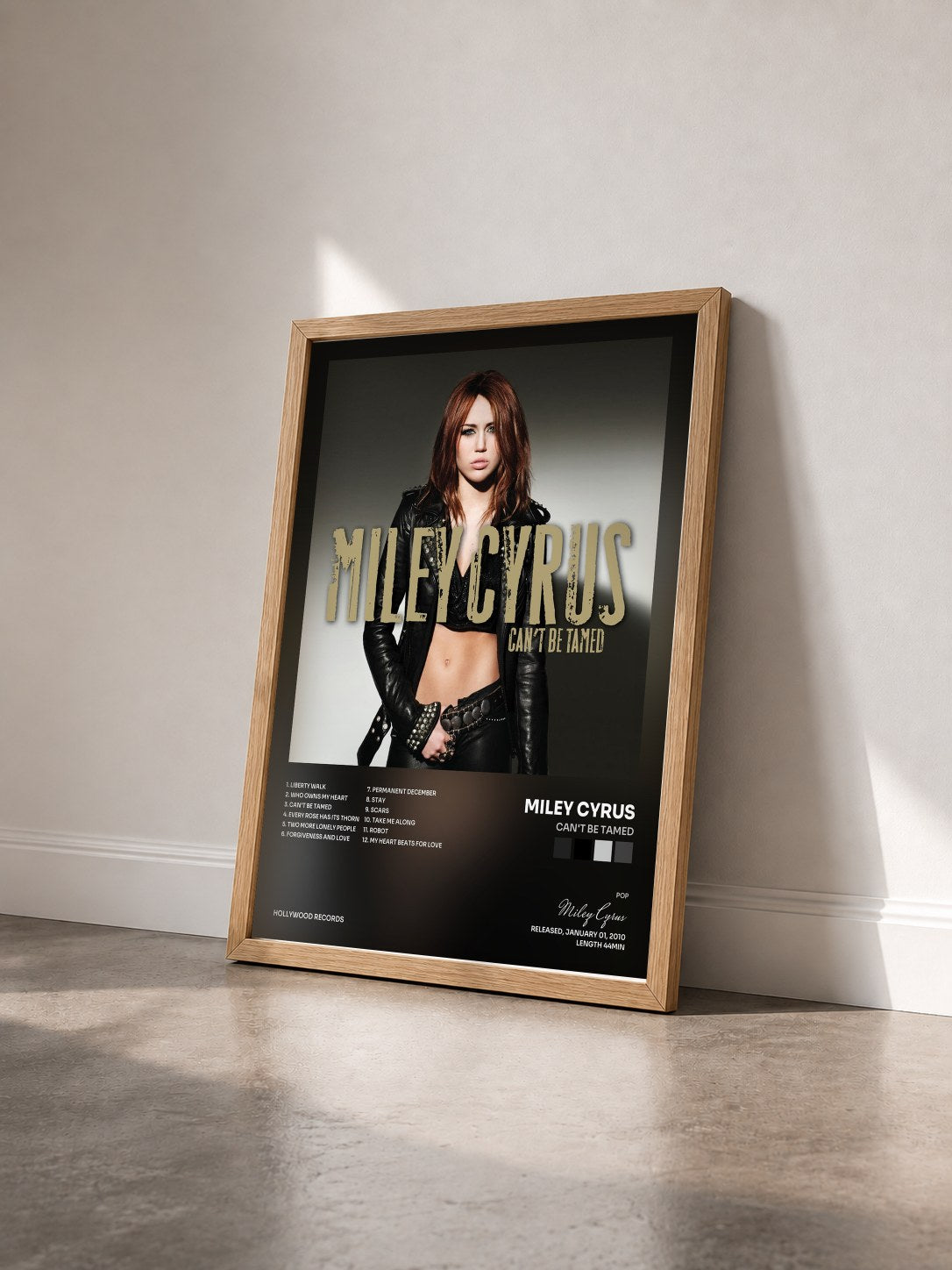 #bois Tableau de l'album Can't Be Tamed de Miley Cyrus vu de trois quarts, cadre en bois brut