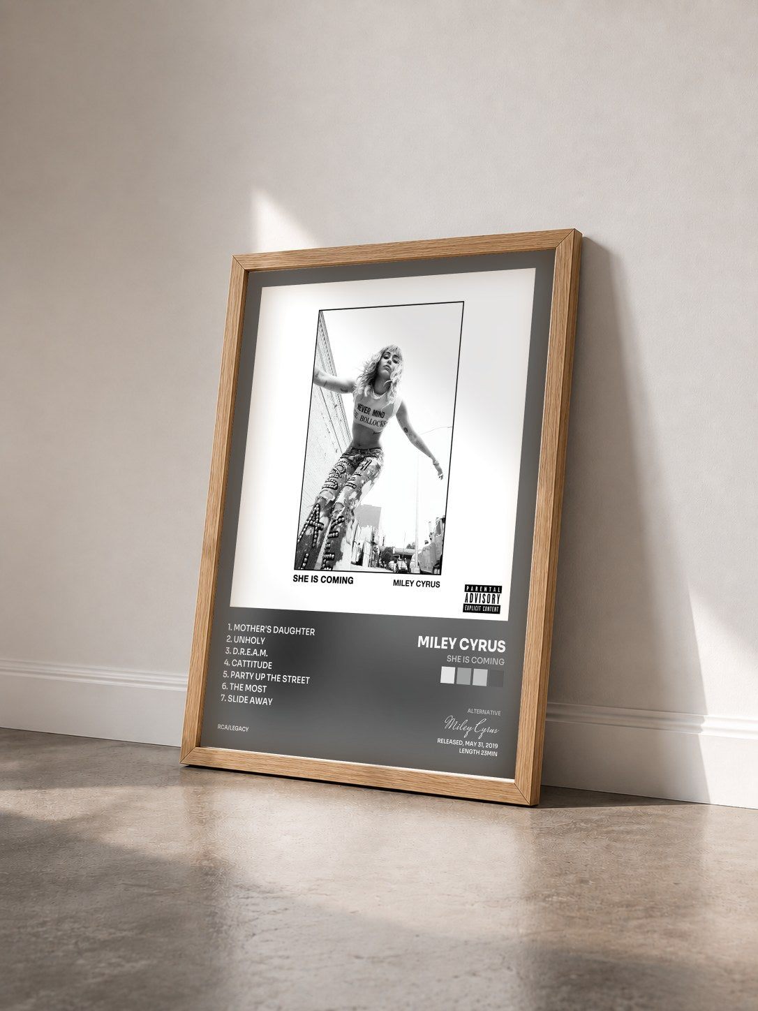 #bois Tableau de l'album SHE IS COMING de Miley Cyrus vu de trois quarts, cadre en bois brut