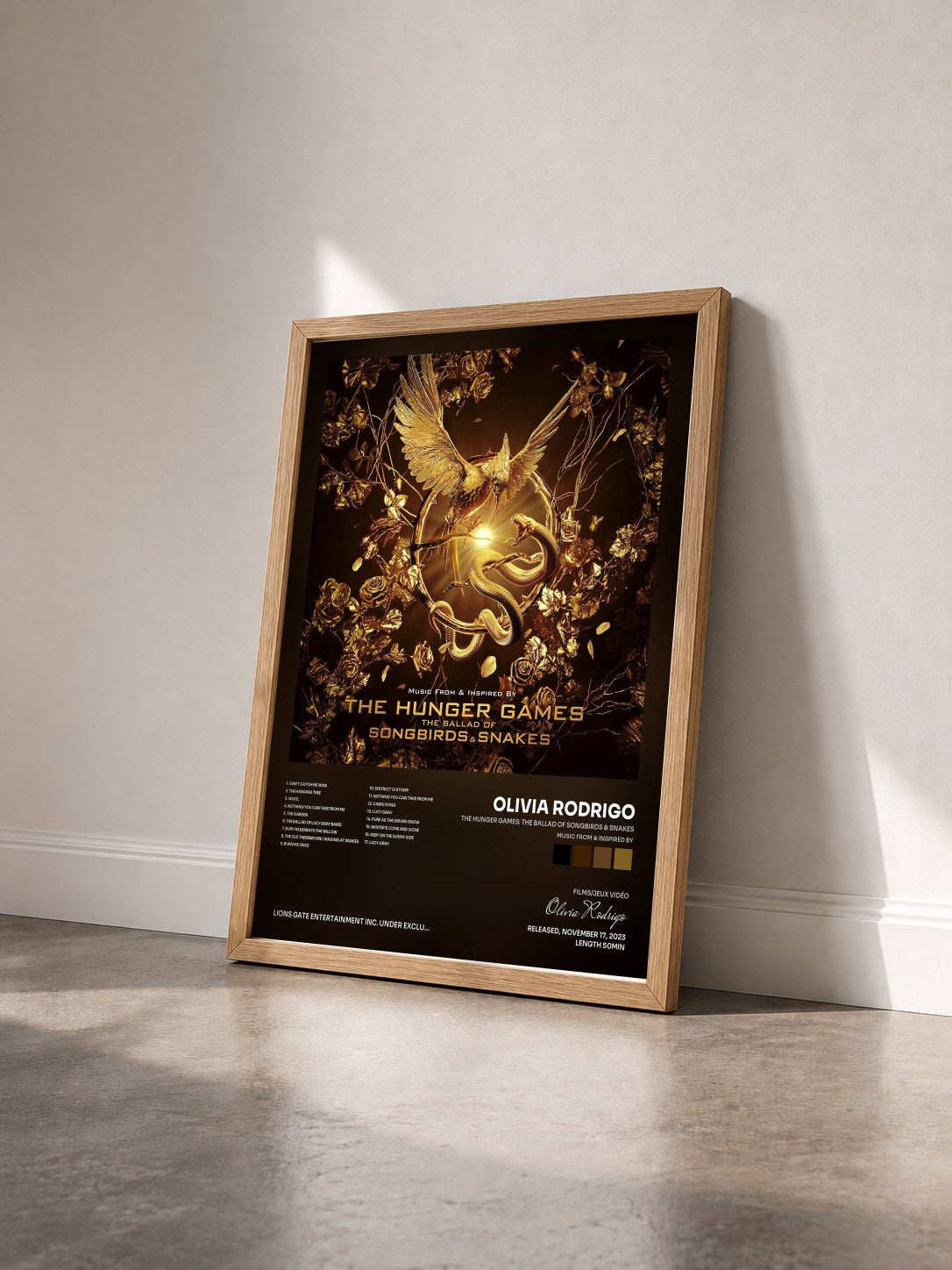#bois Tableau de l'album The Hunger Games: The Ballad of Songbirds & Snakes (Music From & Inspired By) de Olivia Rodrigo vu de trois quarts, cadre en bois brut