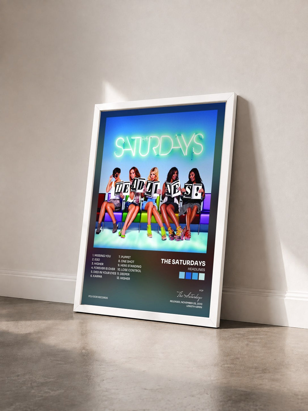 #blanc Tableau de l'album Headlines de The Saturdays vu de trois quarts, cadre blanc