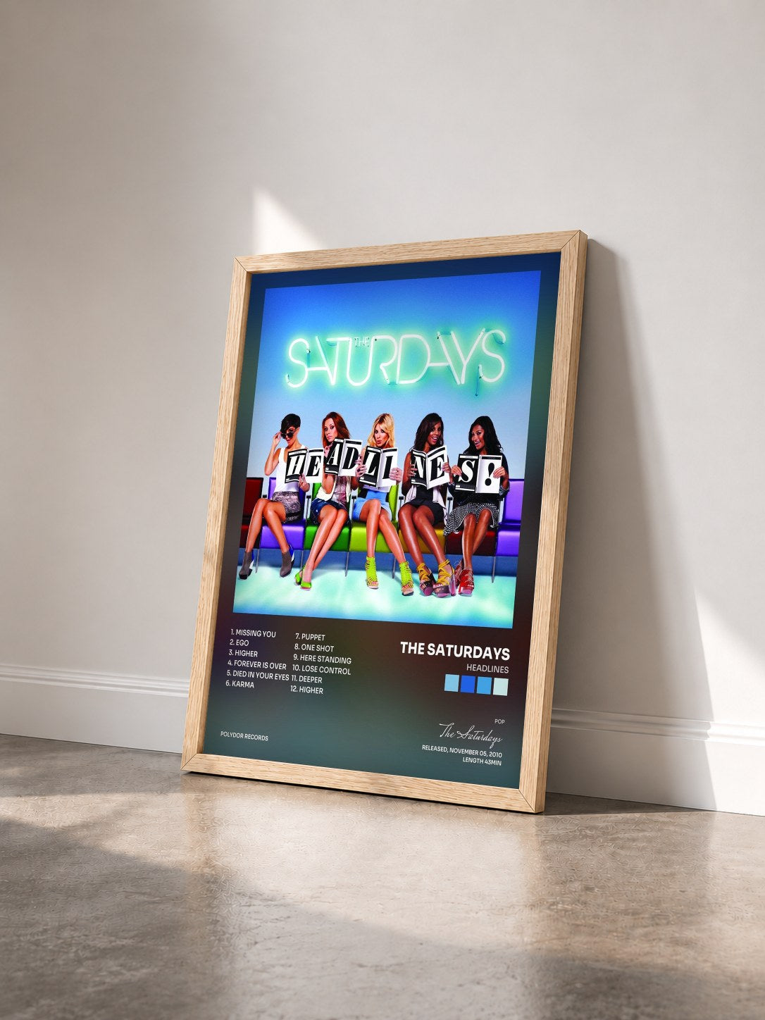 #bois Tableau de l'album Headlines de The Saturdays vu de trois quarts, cadre en bois brut