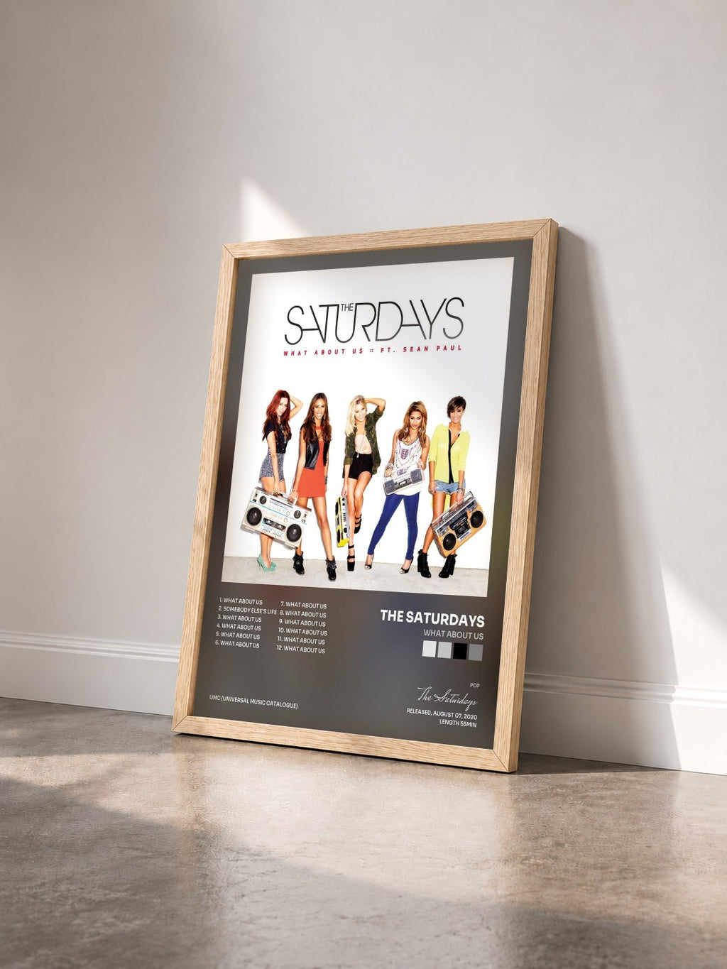 #bois Tableau de l'album What About Us de The Saturdays vu de trois quarts, cadre en bois brut