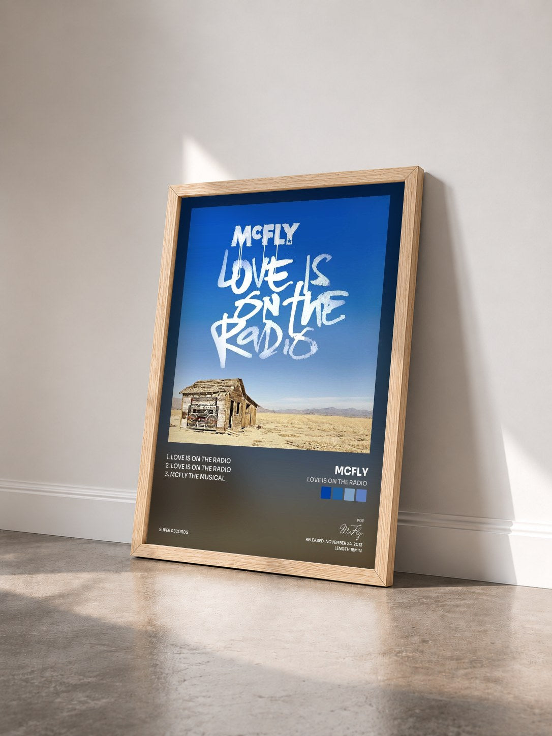 #bois Tableau de l'album Love Is On The Radio de McFly vu de trois quarts, cadre en bois brut