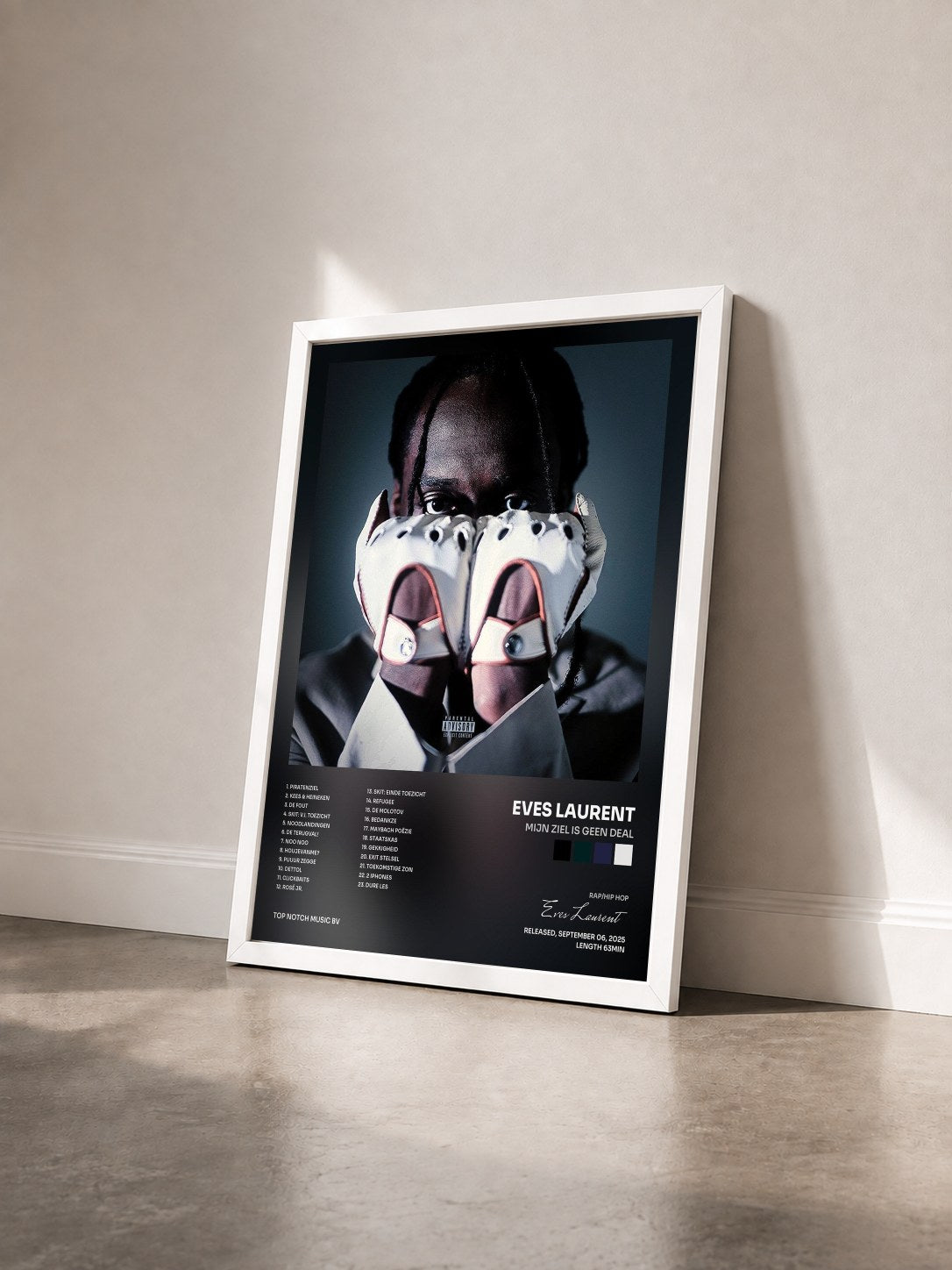 #blanc Tableau de l'album Mijn Ziel Is Geen Deal de Eves Laurent vu de trois quarts, cadre blanc
