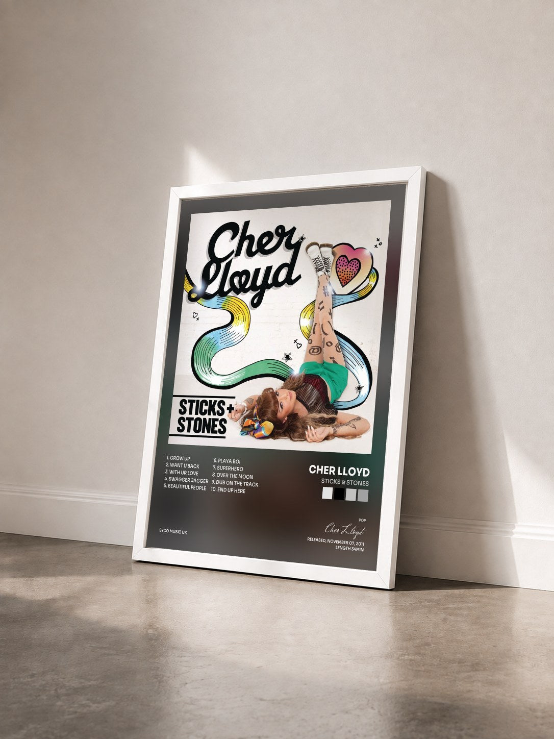 #blanc Tableau de l'album Sticks & Stones de Cher Lloyd vu de trois quarts, cadre blanc