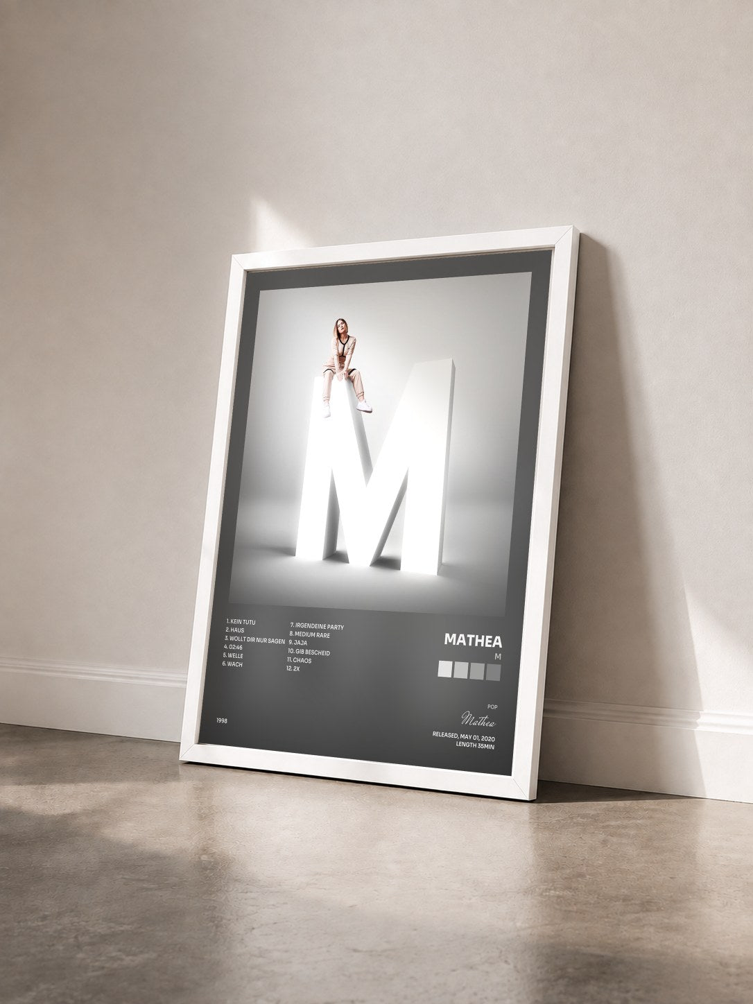 #blanc Tableau de l'album M de Mathea vu de trois quarts, cadre blanc