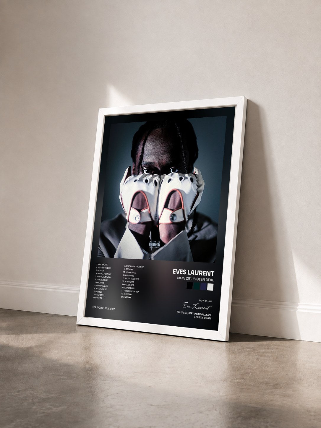 #blanc Tableau de l'album Mijn Ziel Is Geen Deal de Eves Laurent vu de trois quarts, cadre blanc