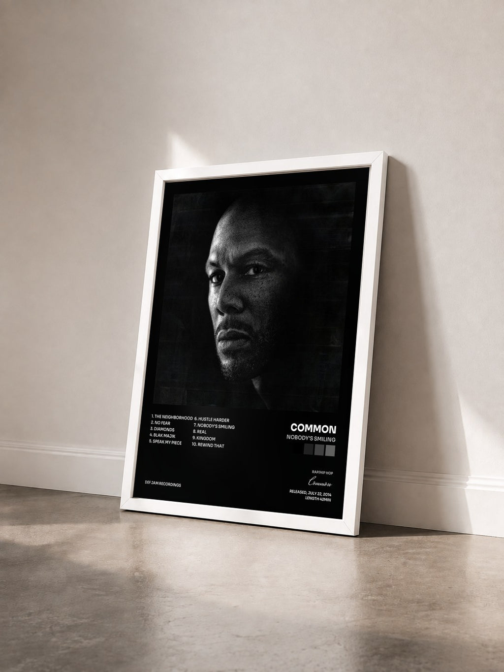 #blanc Nobody's Smiling by Common as a framed art print seen at an angle, white frame