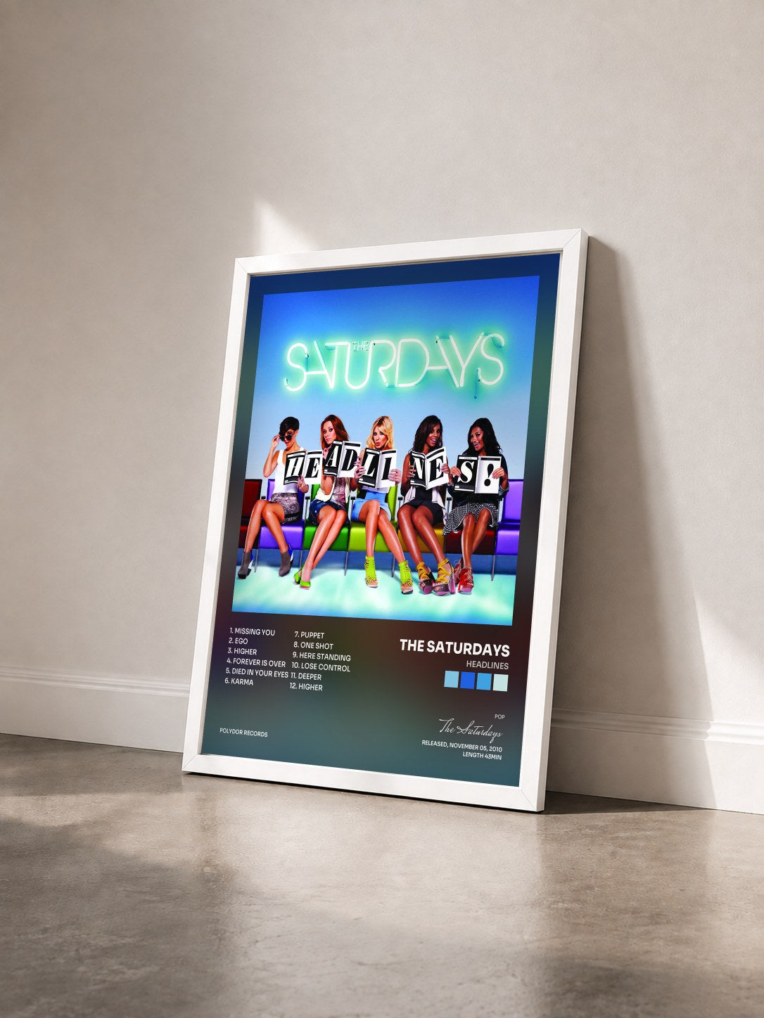 #blanc Tableau de l'album Headlines de The Saturdays vu de trois quarts, cadre blanc