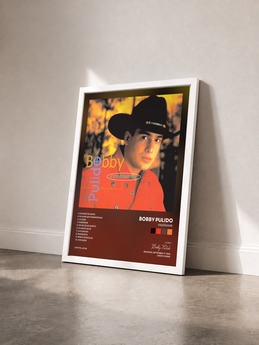#blanc Tableau de l'album Enséñame de Bobby Pulido vu de trois quarts, cadre blanc