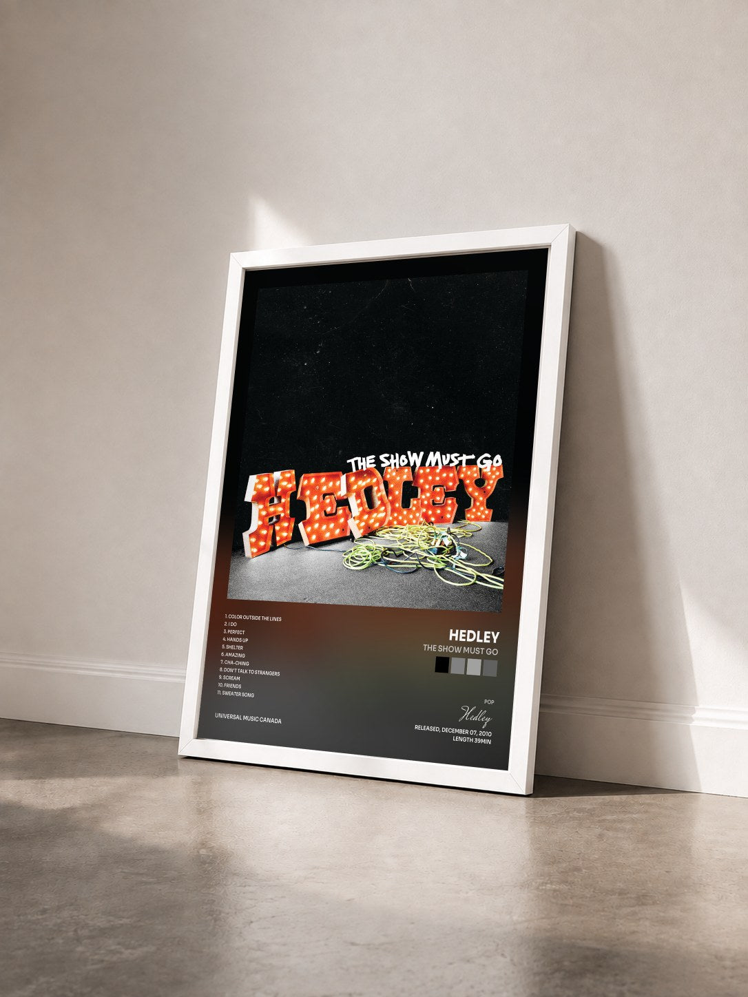 #blanc Tableau de l'album The Show Must Go de Hedley vu de trois quarts, cadre blanc