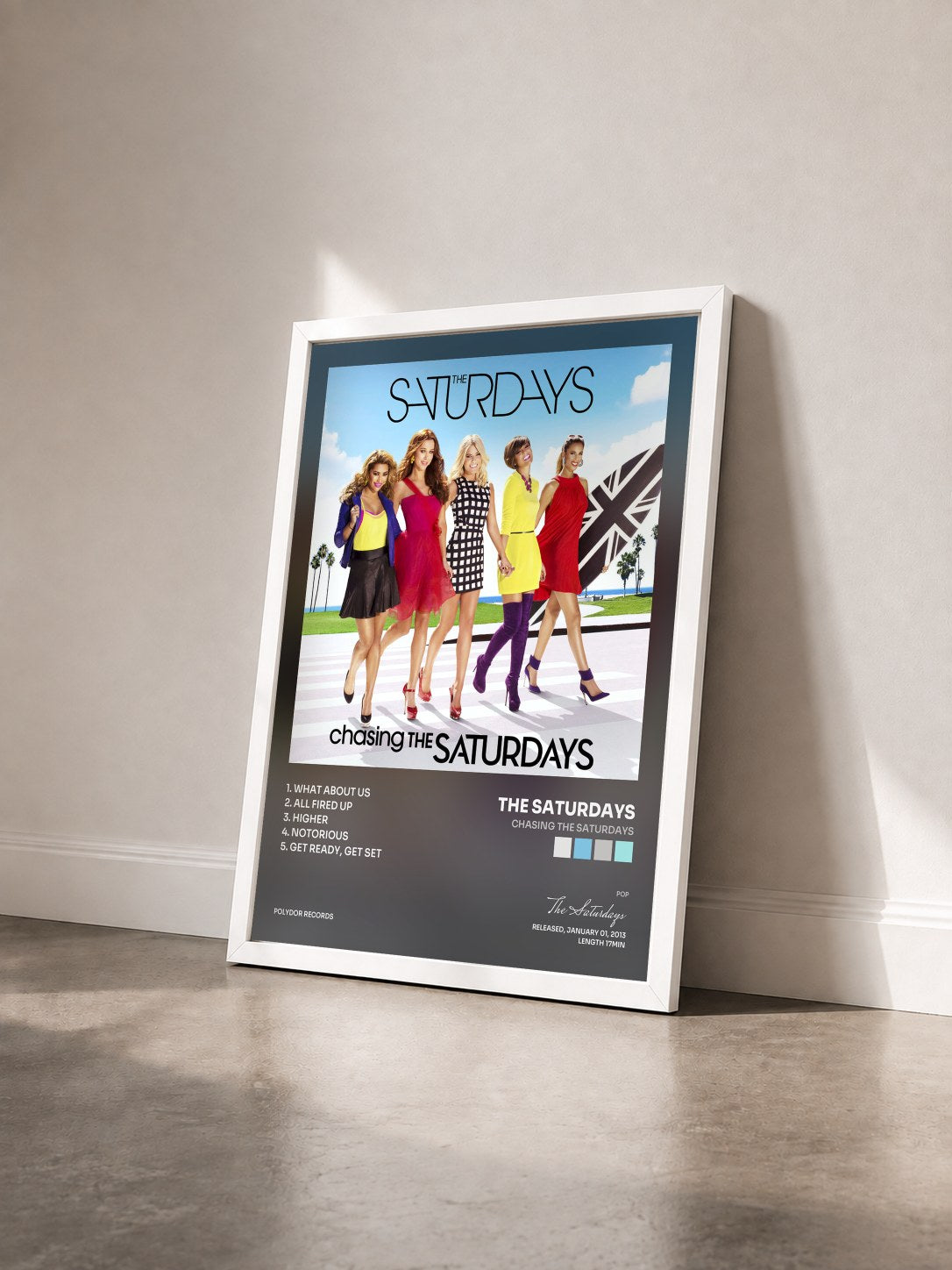 #blanc Tableau de l'album Chasing The Saturdays de The Saturdays vu de trois quarts, cadre blanc