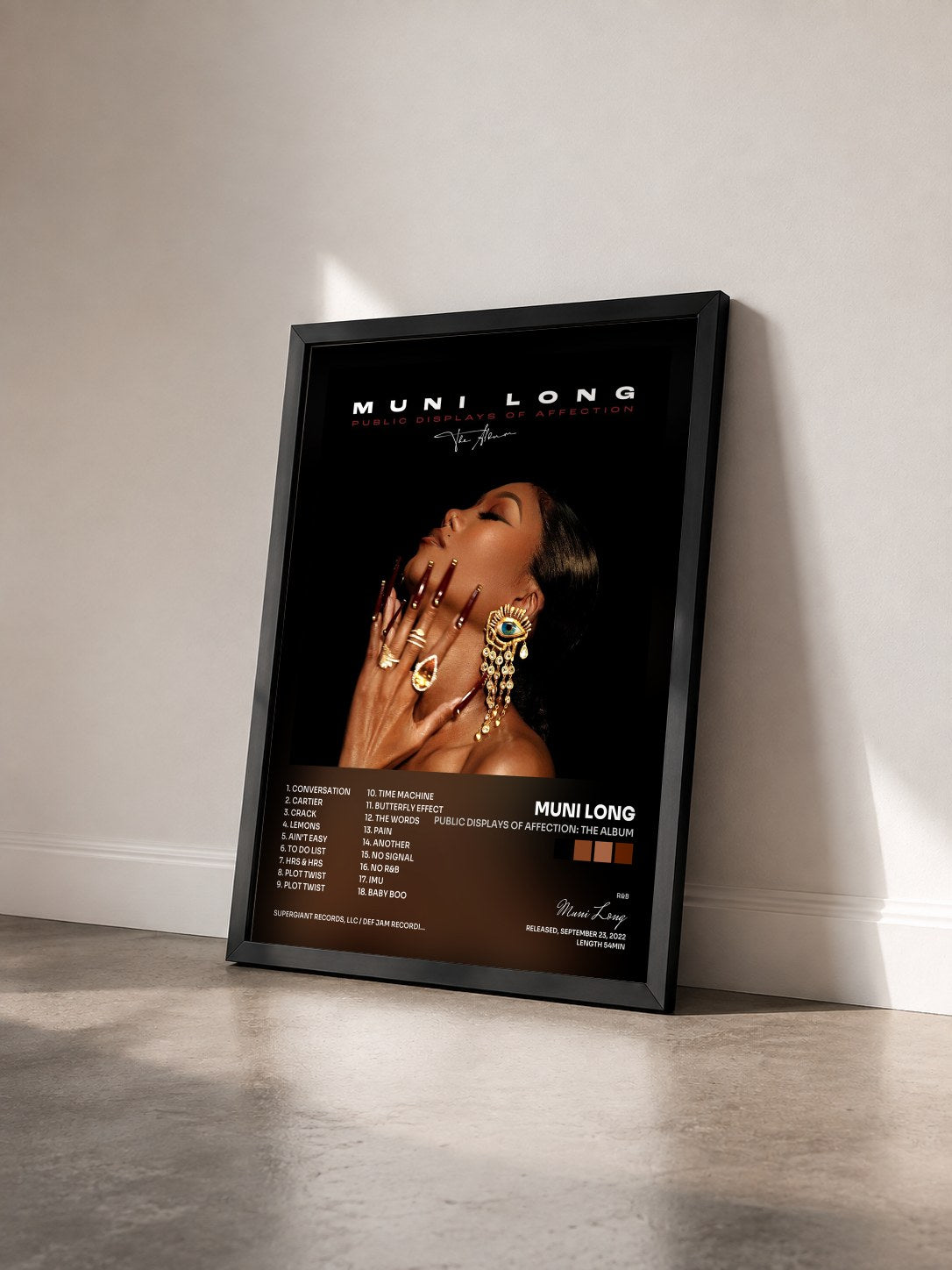 #noir Tableau de l'album Public Displays Of Affection: The Album de Muni Long vu de trois quarts, cadre noir