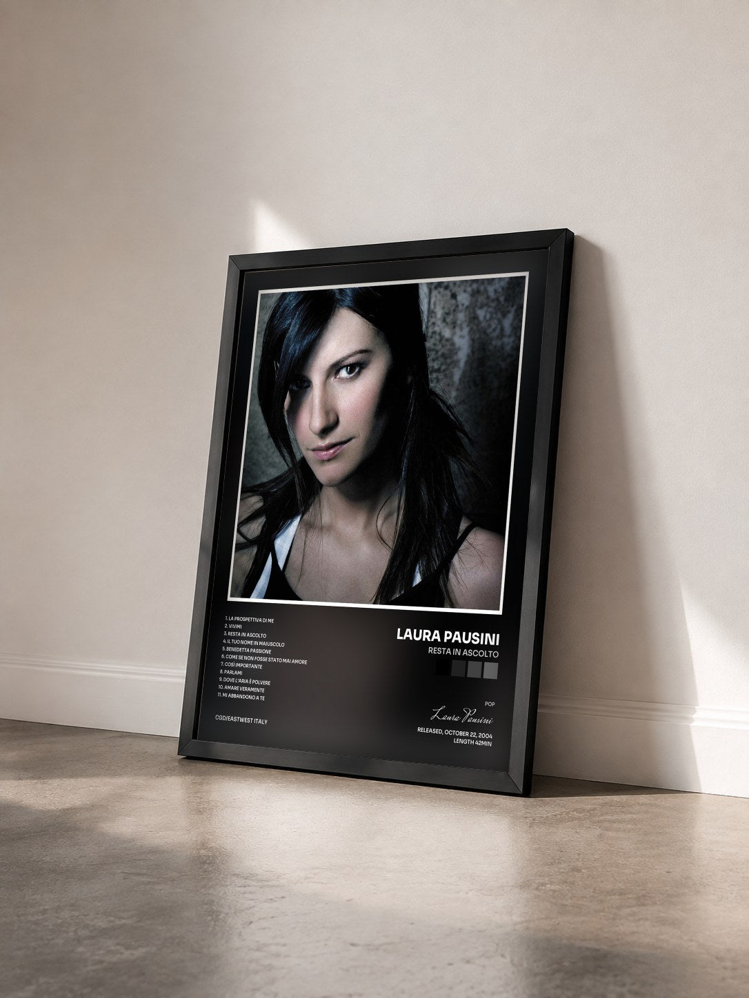 #noir Tableau de l'album Resta in ascolto de Laura Pausini vu de trois quarts, cadre noir