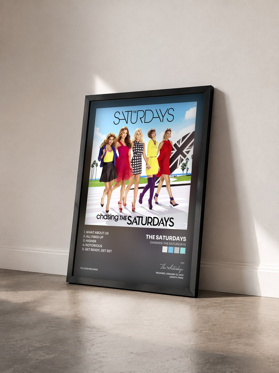 #noir Tableau de l'album Chasing The Saturdays de The Saturdays vu de trois quarts, cadre noir