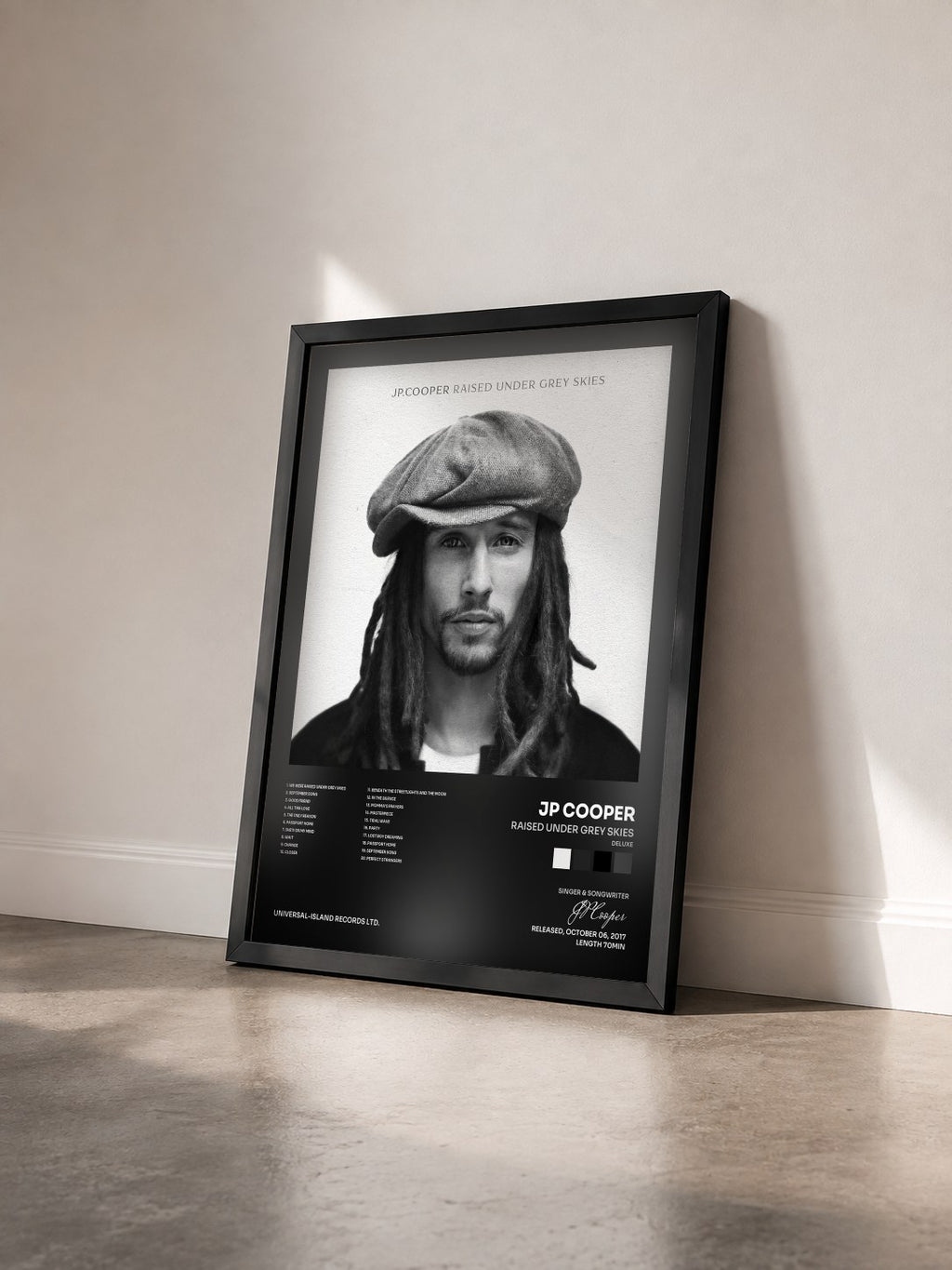 #noir Tableau de l'album Raised Under Grey Skies (Deluxe) de JP Cooper vu de trois quarts, cadre noir