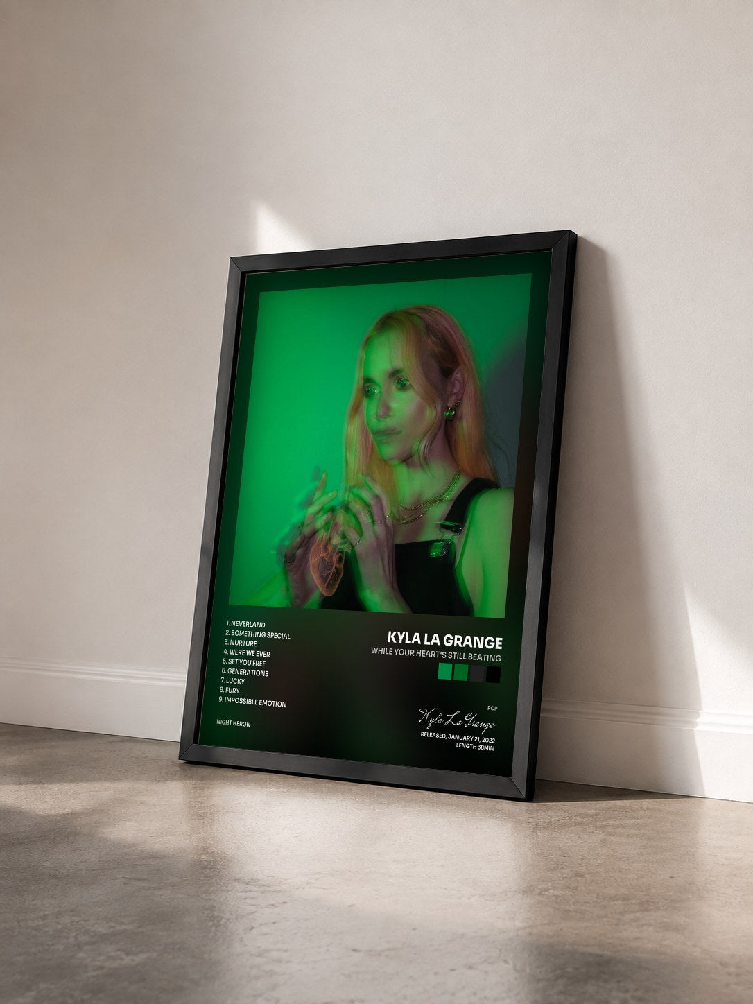 #noir Tableau de l'album While Your Heart's Still Beating de Kyla La Grange vu de trois quarts, cadre noir