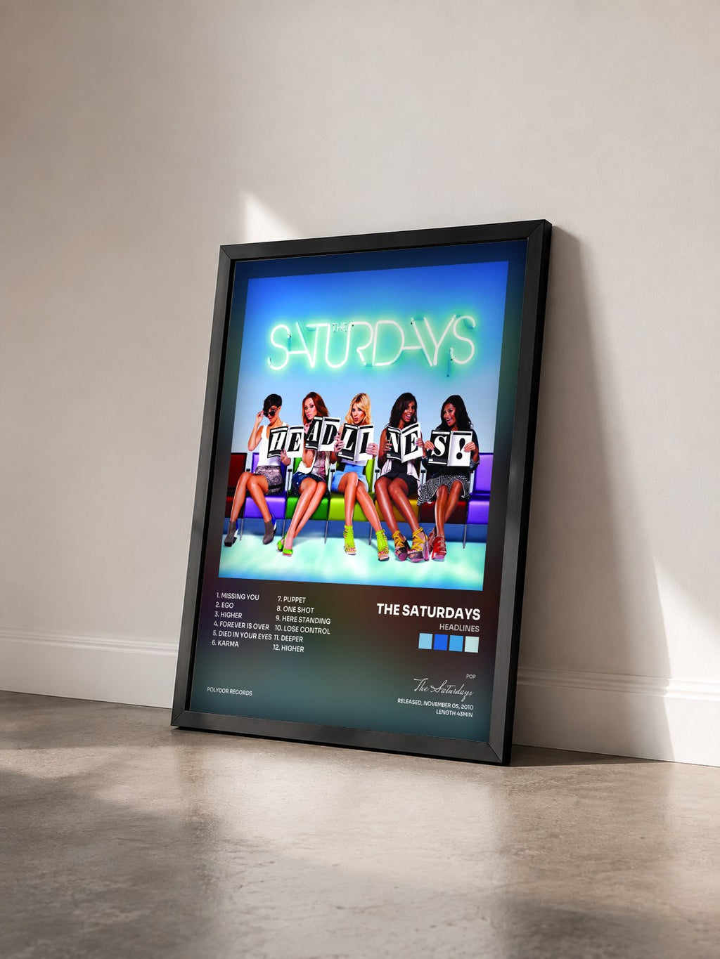 #noir Tableau de l'album Headlines de The Saturdays vu de trois quarts, cadre noir