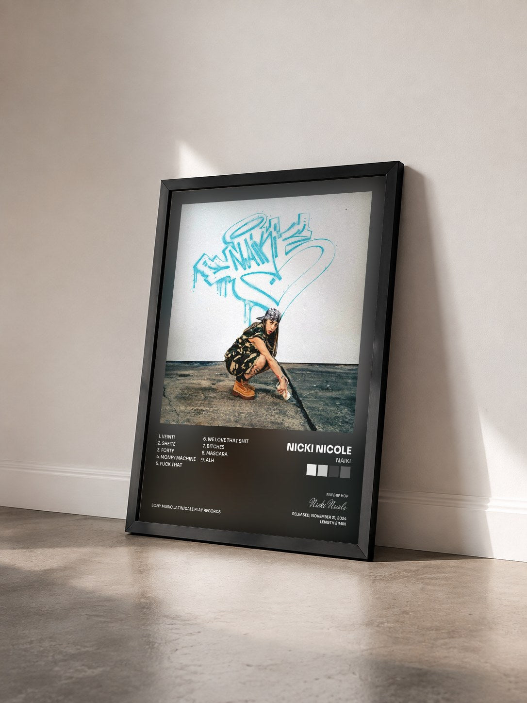 #noir Tableau de l'album NAIKI de Nicki Nicole vu de trois quarts, cadre noir