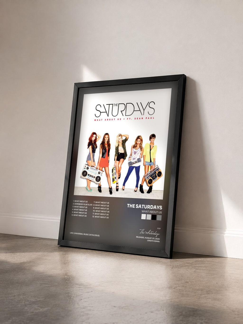 #noir Tableau de l'album What About Us de The Saturdays vu de trois quarts, cadre noir