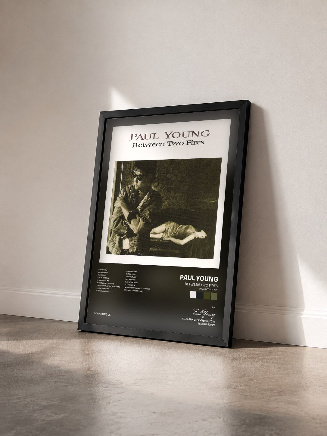 #noir Tableau de l'album Between Two Fires (Expanded Edition) de Paul Young vu de trois quarts, cadre noir