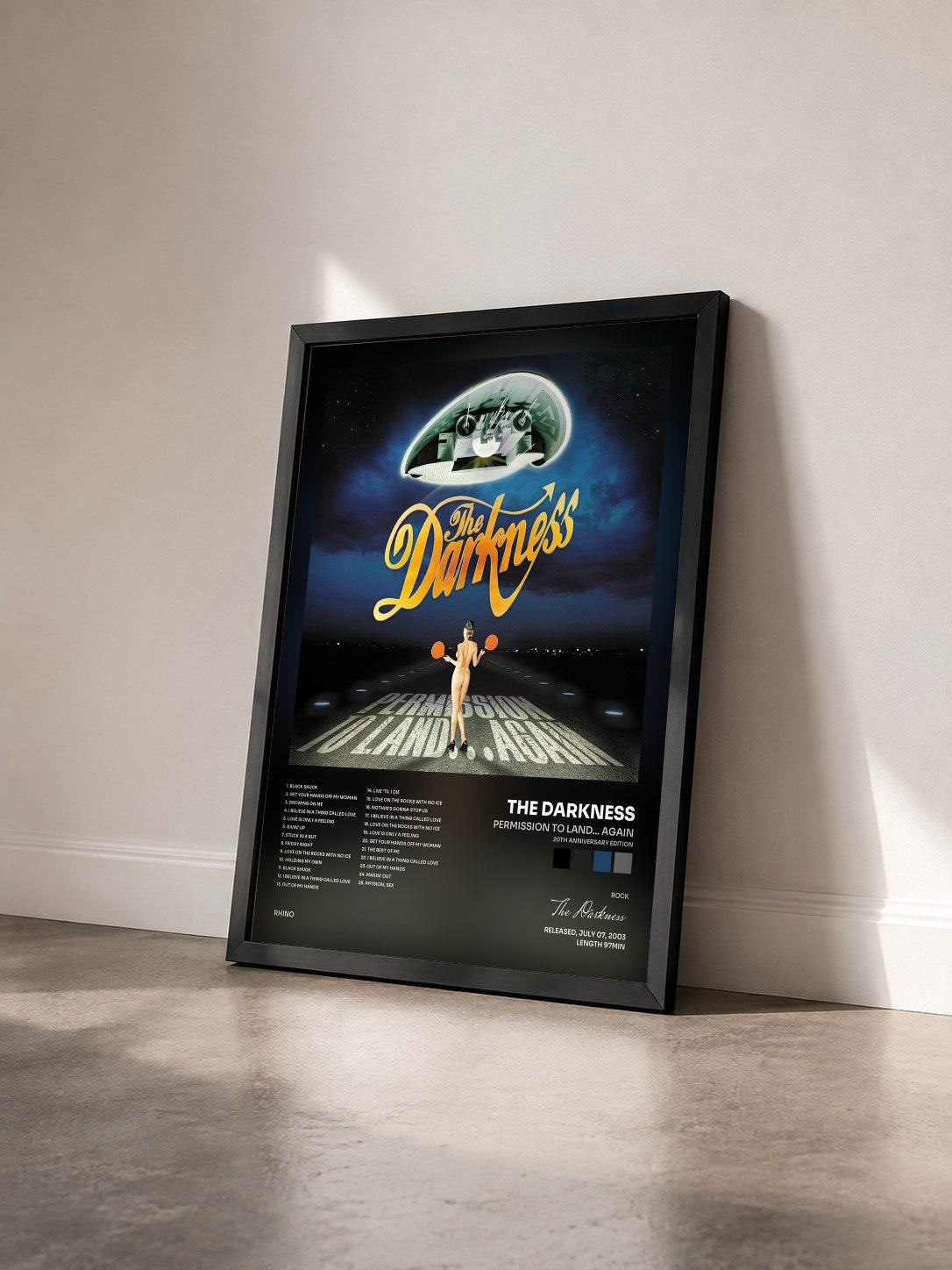 #noir Tableau de l'album Permission To Land... Again (20th Anniversary Edition) de The Darkness vu de trois quarts, cadre noir