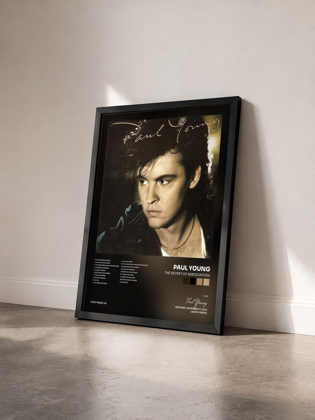 #noir Tableau de l'album The Secret Of Association de Paul Young vu de trois quarts, cadre noir