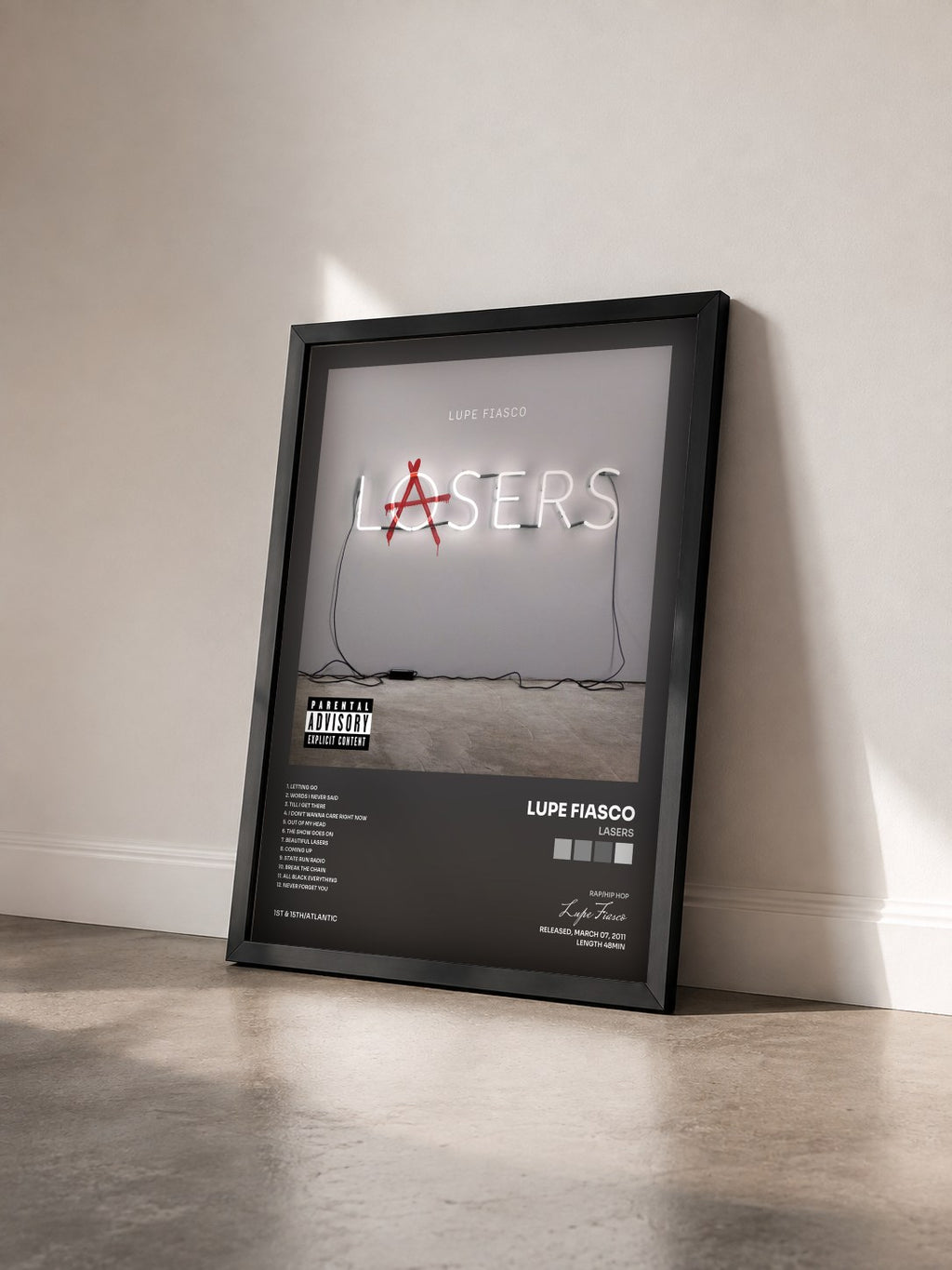 #noir Tableau de l'album Lasers de Lupe Fiasco vu de trois quarts, cadre noir