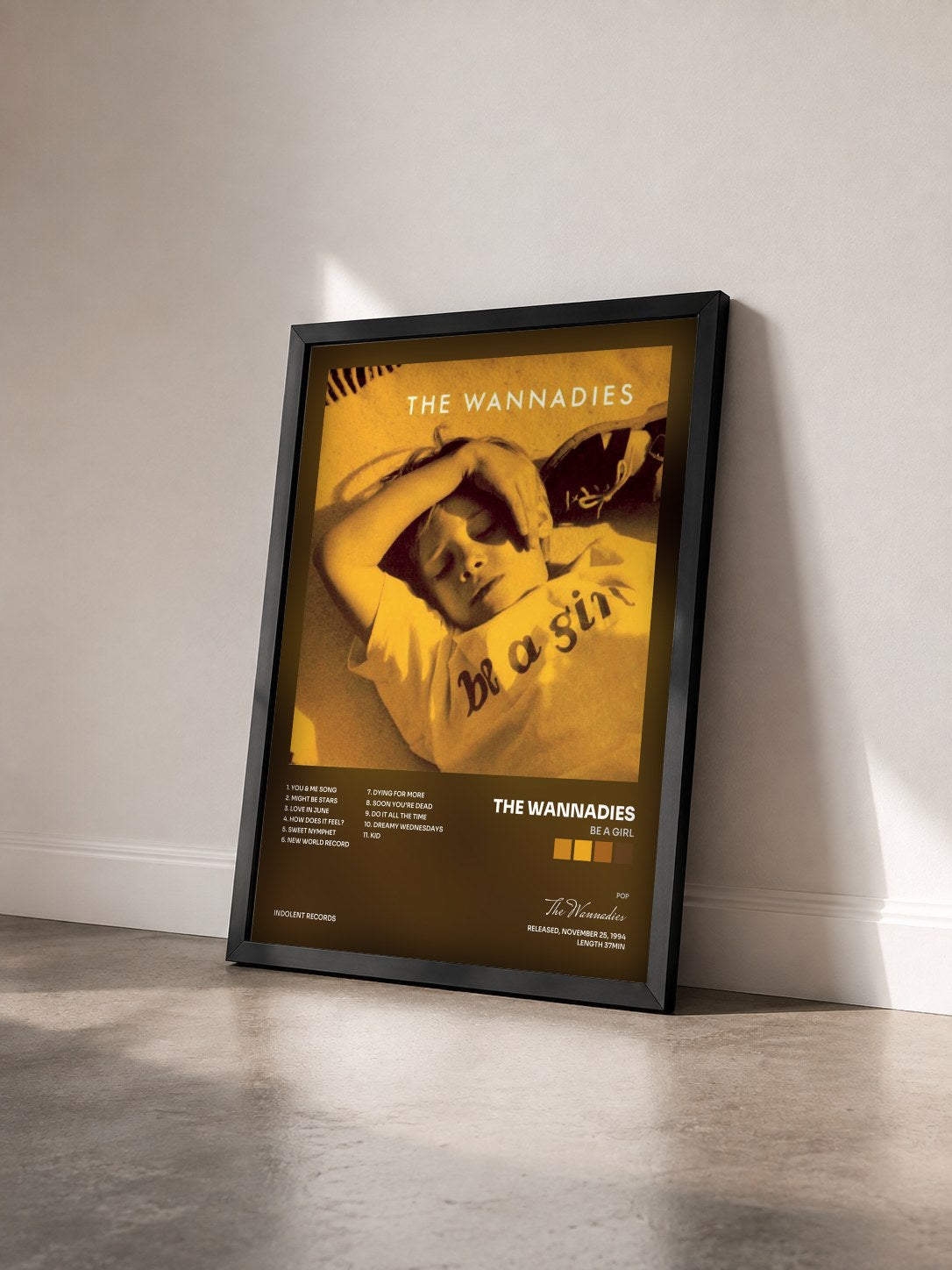 #noir Tableau de l'album Be A Girl de The Wannadies vu de trois quarts, cadre noir
