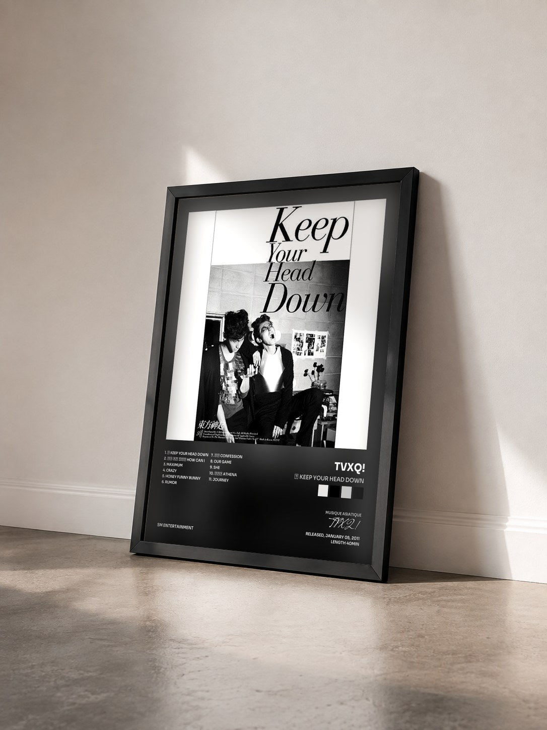 #noir Tableau de l'album 왜 Keep Your Head Down de TVXQ! vu de trois quarts, cadre noir