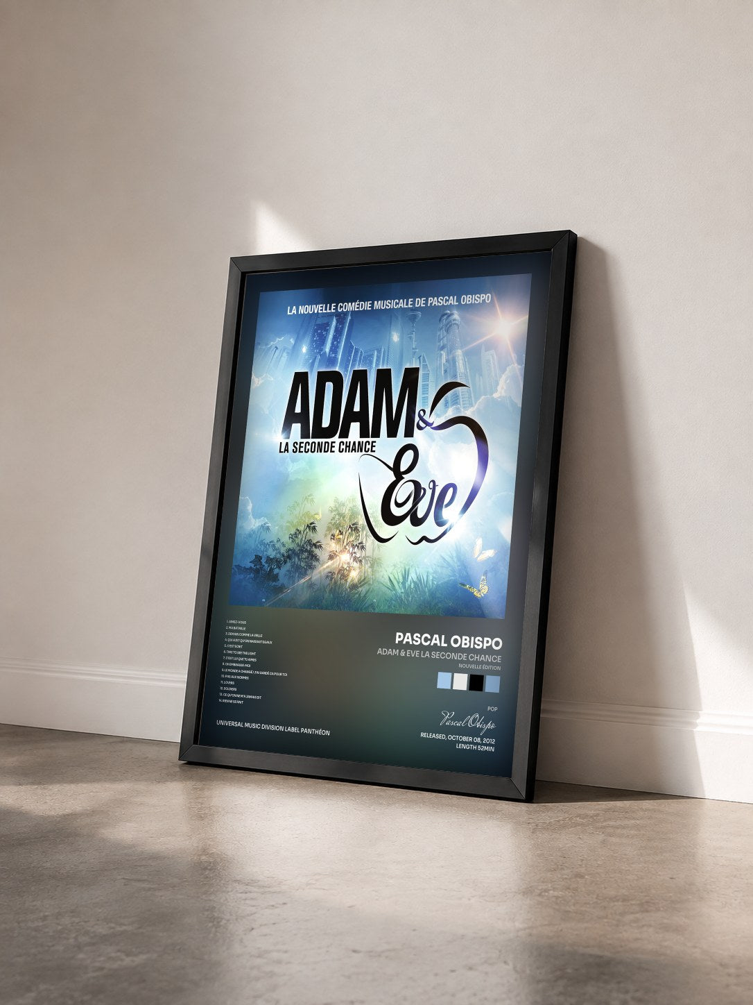 #noir Adam & Eve La Seconde Chance (nouvelle édition) by Pascal Obispo as a framed art print seen at an angle, black frame
