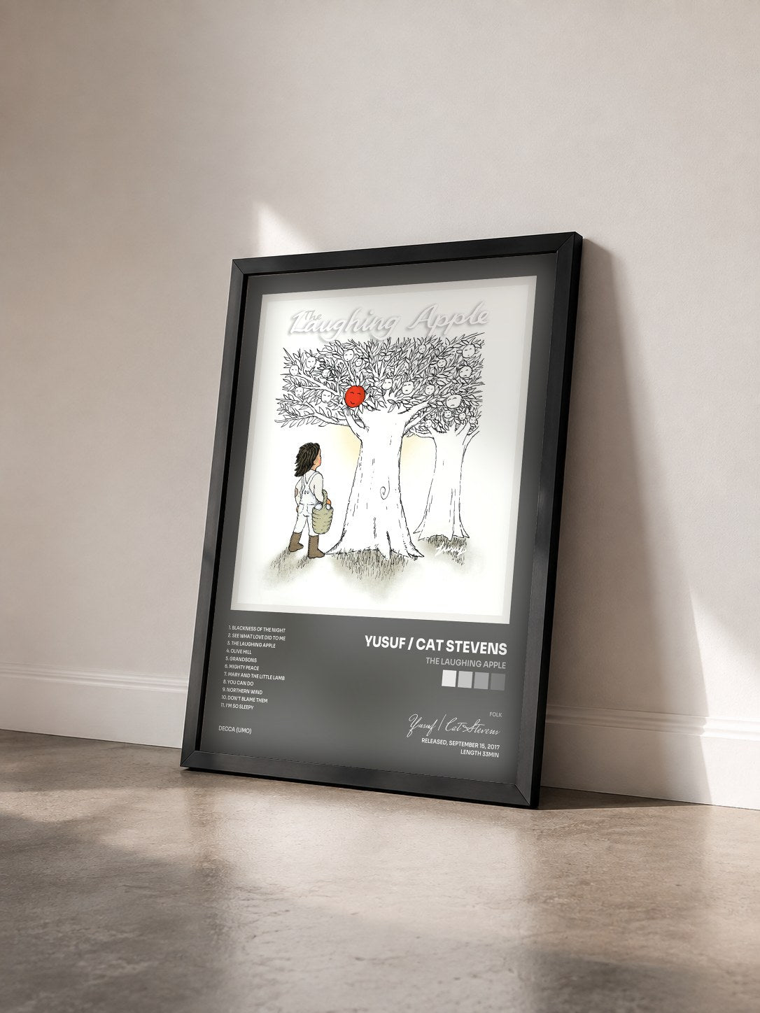 #noir Tableau de l'album The Laughing Apple de Yusuf / Cat Stevens vu de trois quarts, cadre noir