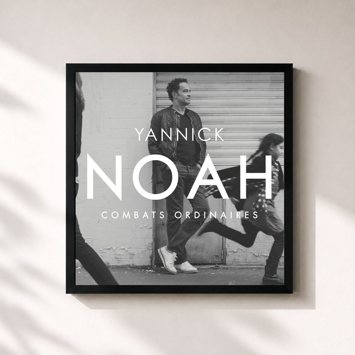 #noir Combats Ordinaires by Yannick Noah as a square framed art print, black 32x32 cm frame