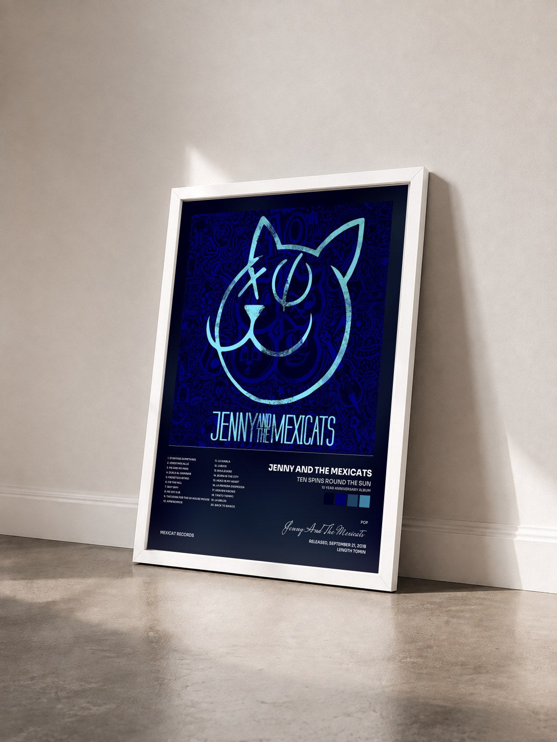 #blanc Tableau de l'album Ten Spins Round the Sun (10 Year Anniversary Album) de Jenny And The Mexicats vu de trois quarts, cadre blanc