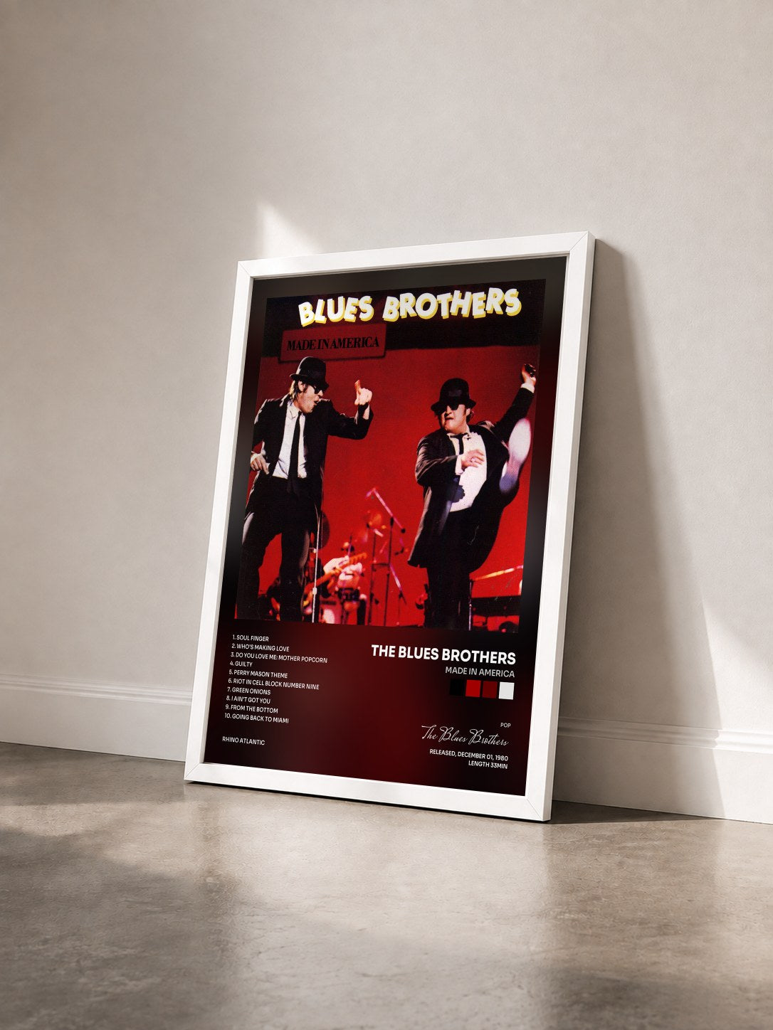 #blanc Made in America by The Blues Brothers as a framed art print seen at an angle, white frame