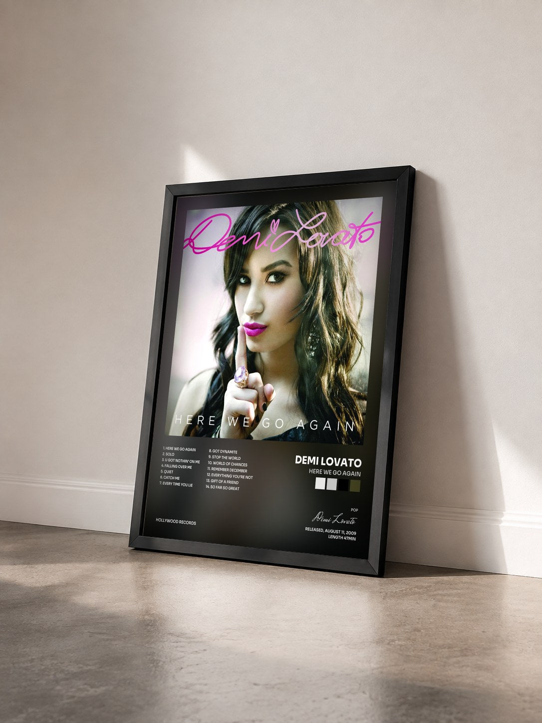 #noir Tableau de l'album Here We Go Again de Demi Lovato vu de trois quarts, cadre noir