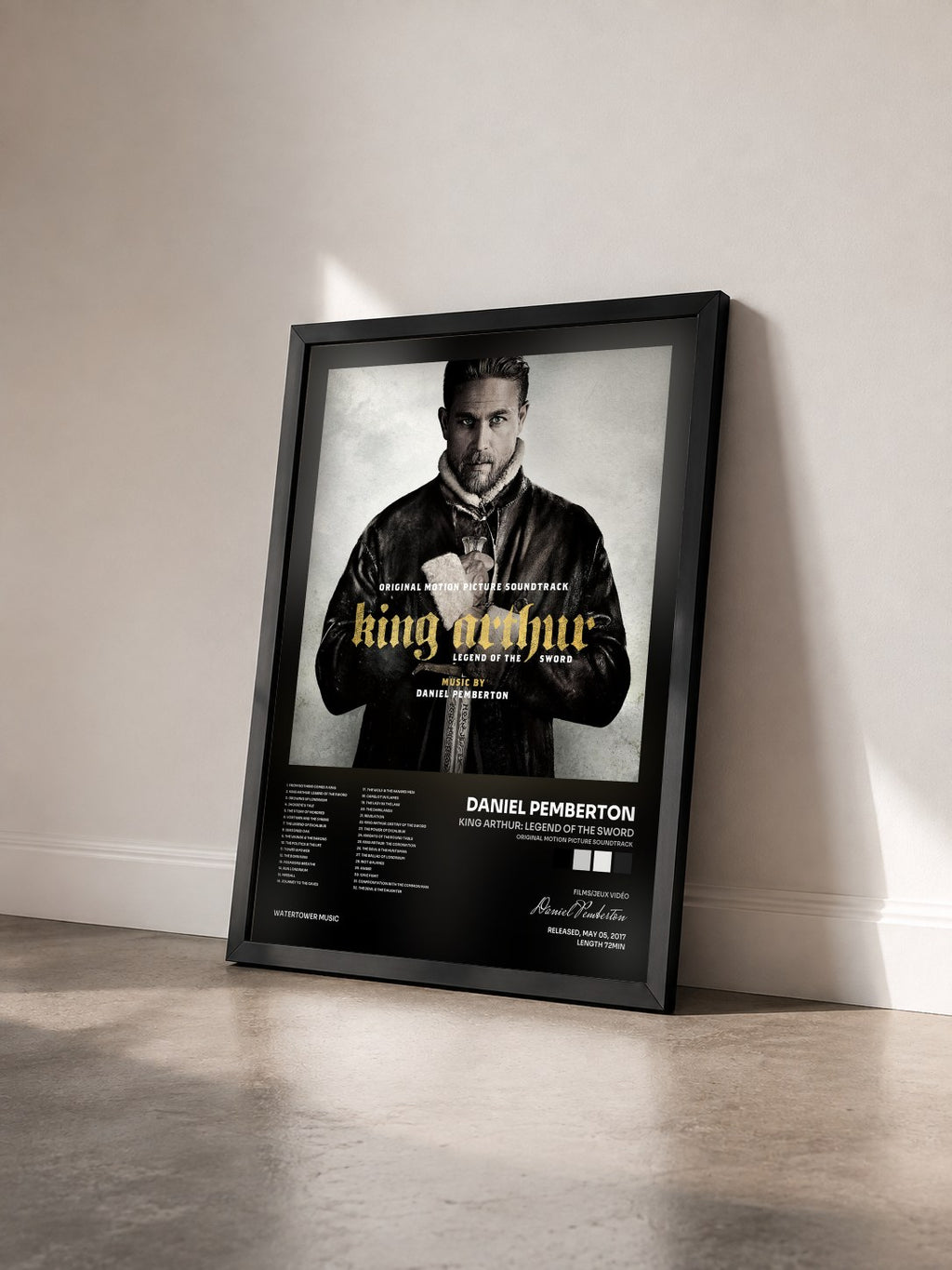 #noir King Arthur: Legend of the Sword (Original Motion Picture Soundtrack) by Daniel Pemberton as a framed art print seen at an angle, black frame