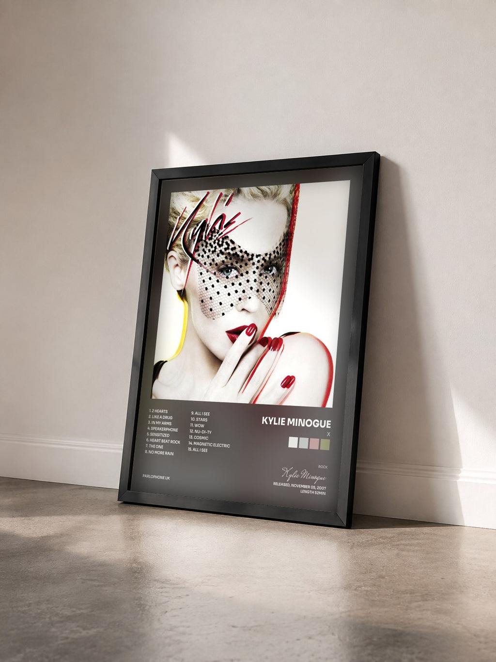 #noir Tableau de l'album X de Kylie Minogue vu de trois quarts, cadre noir