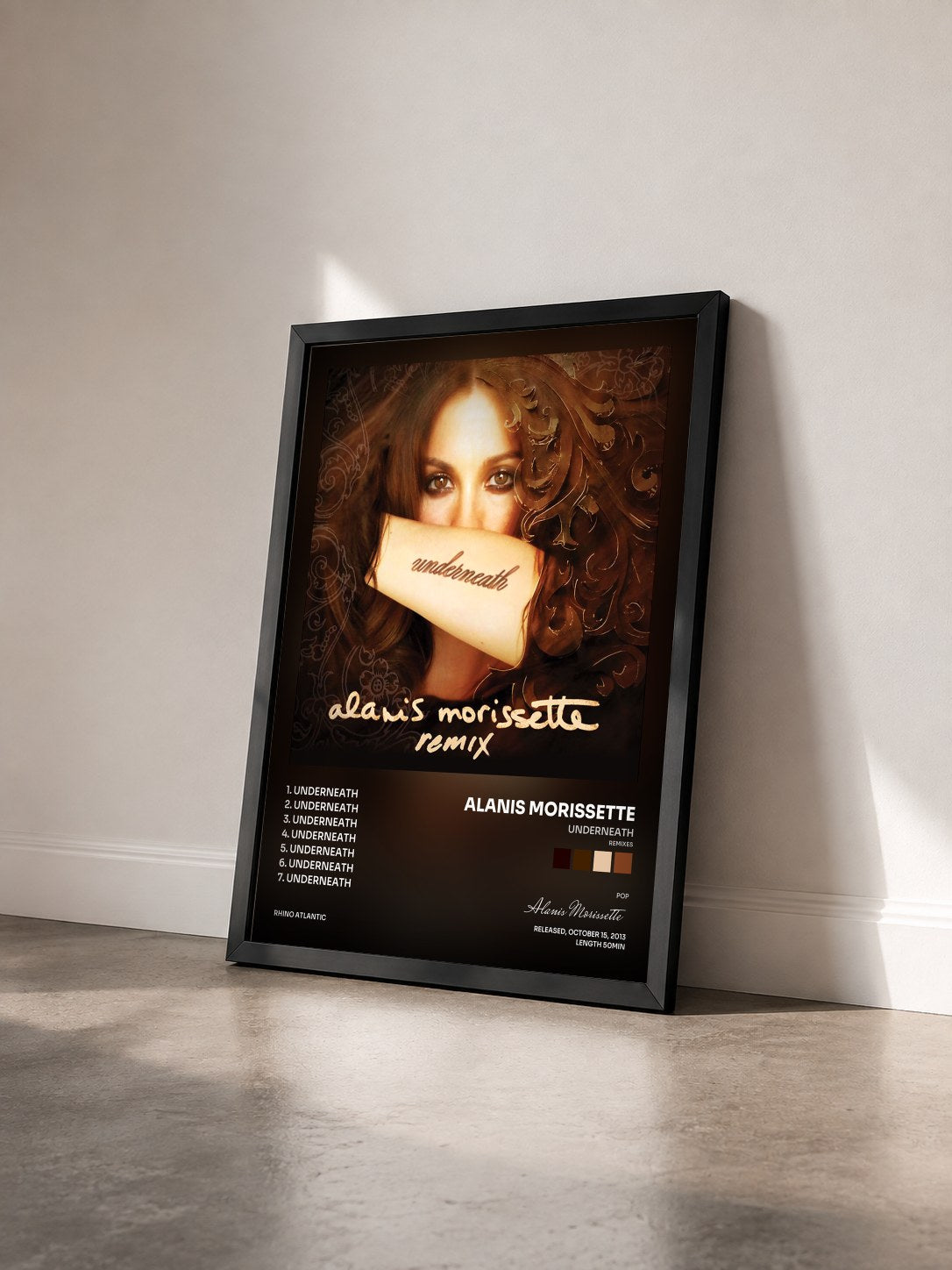 #noir Tableau de l'album Underneath (Remixes) de Alanis Morissette vu de trois quarts, cadre noir