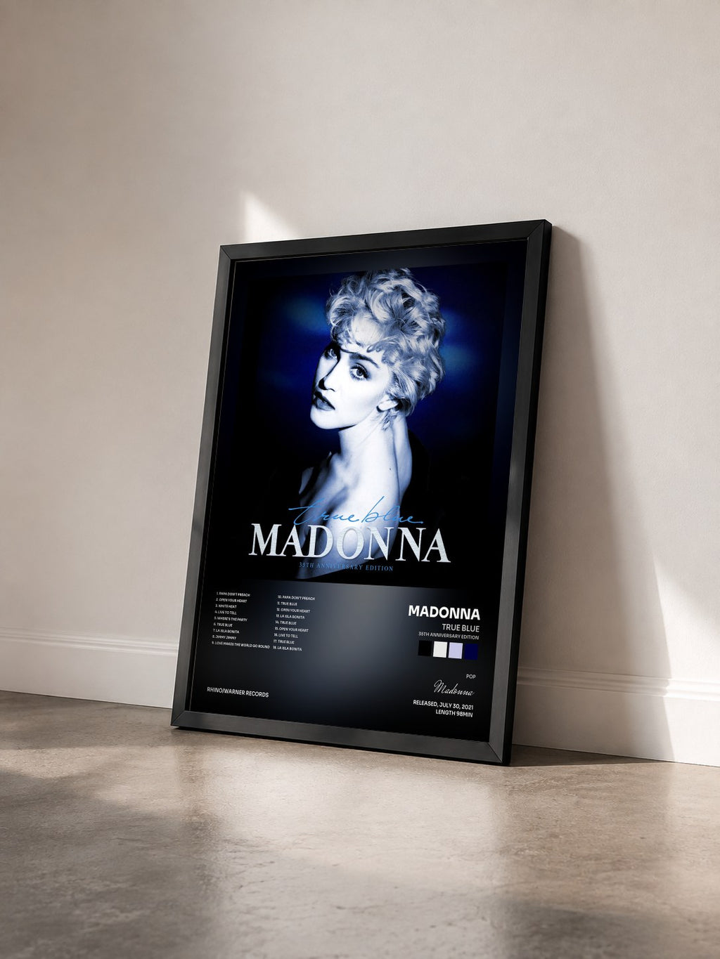 #noir True Blue (35th Anniversary Edition) by Madonna as a framed art print seen at an angle, black frame