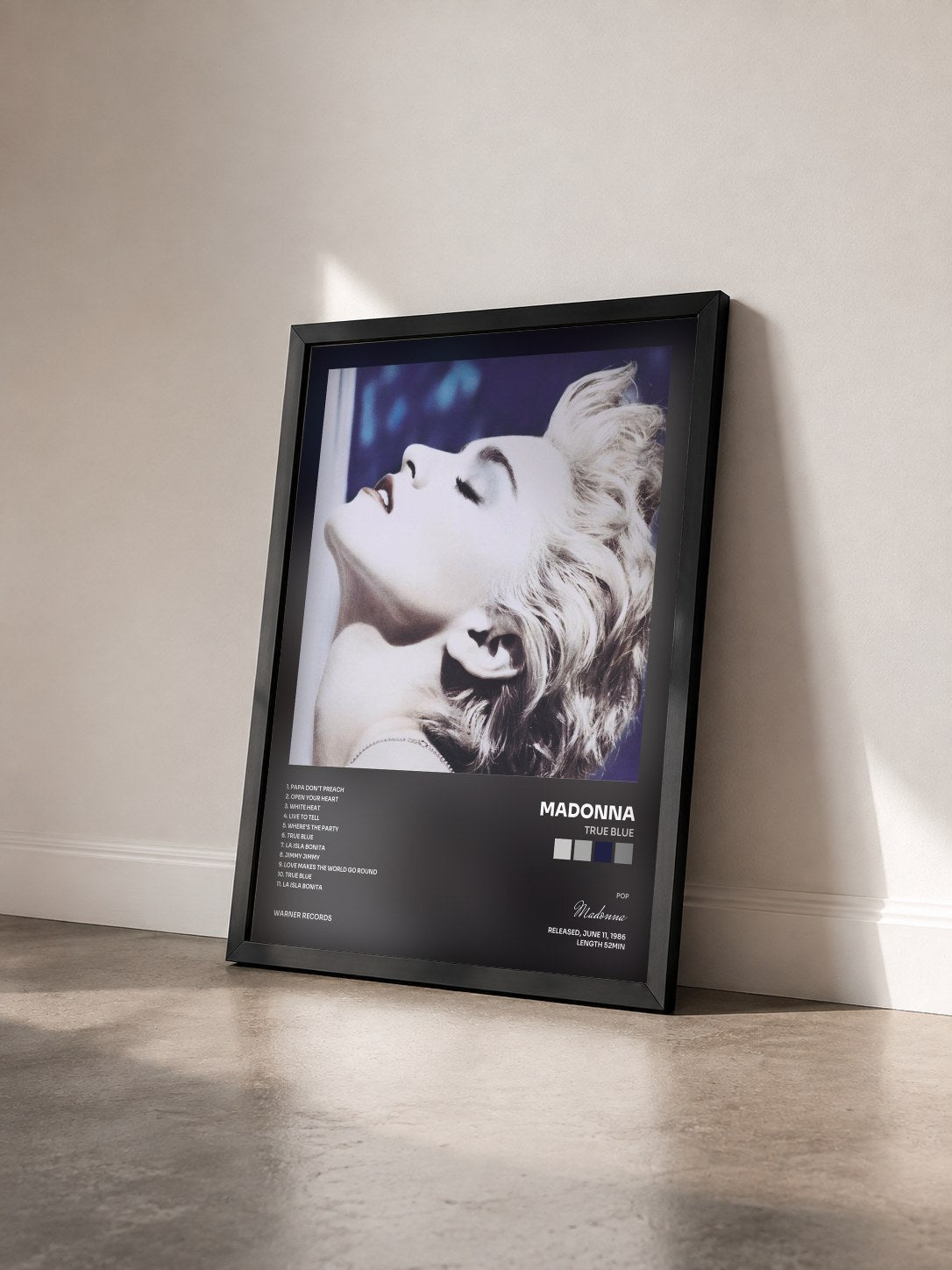 #noir True Blue by Madonna as a framed art print seen at an angle, black frame