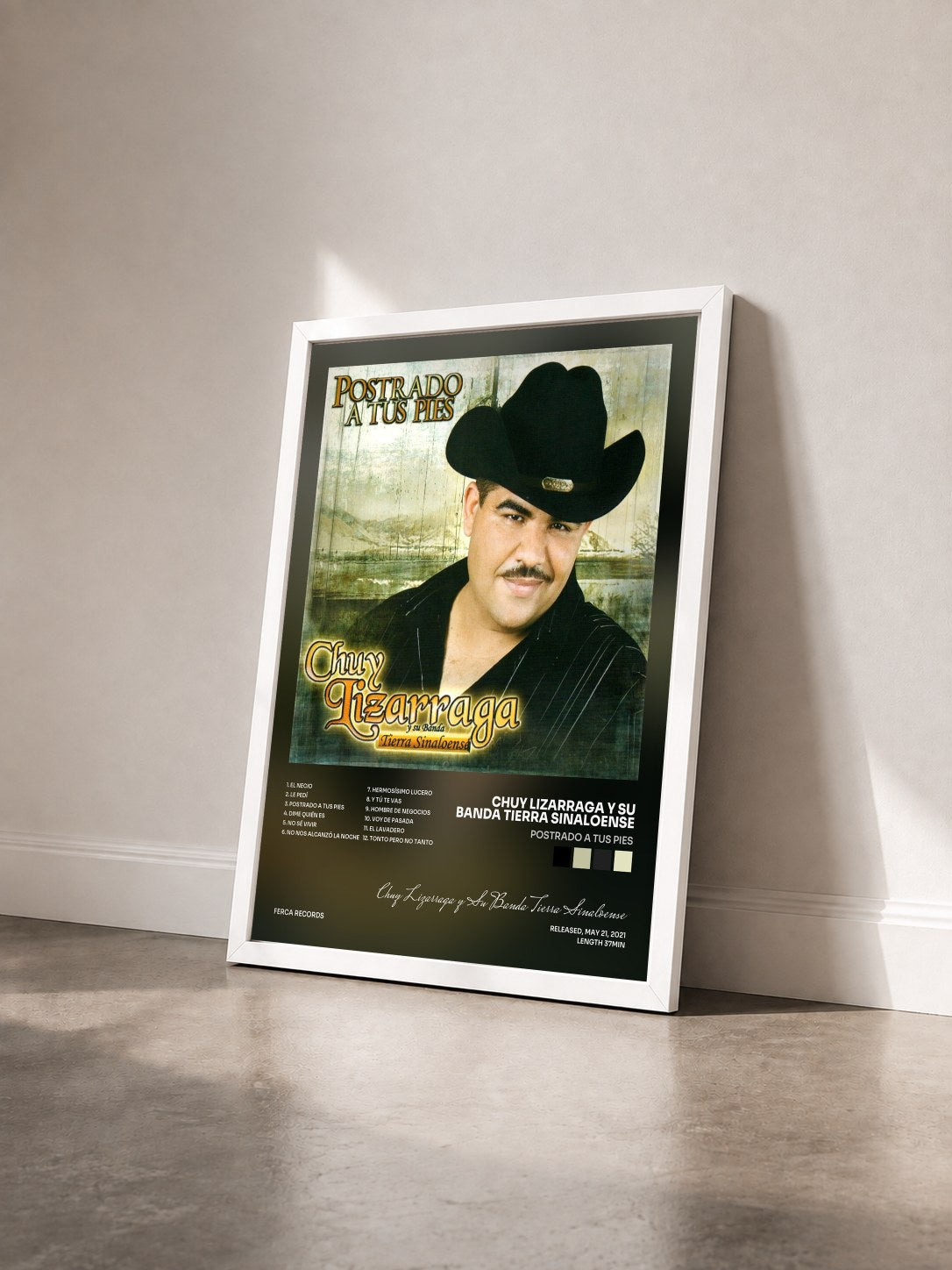 #blanc Tableau de l'album Postrado a Tus Pies de Chuy Lizarraga y Su Banda Tierra Sinaloense vu de trois quarts, cadre blanc